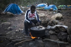  In this Sunday, Nov. 9, 2014 file photo, a Guinean immigrant cooks dinner at a clandestine immigrant camp located at the Mount Gourougou, in the Moroccan province of Nador. Moroccan security forces have arrested hundreds of people in a sweep through a mountainous area where migrants had been living near the Spanish coastal enclave of Melilla, activists said Wednesday, Feb. 11, 2015. The Moroccan Association for Human Rights said that 1,200 migrants had been detained and most bussed to remote parts of the country in the south in an apparent effort to prevent them from trying cross into the Spanish enclave. (Santi Palacios, File/Associated Press)