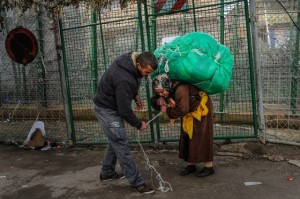 A man ties a huge package onto a woman's back(David Ramos/Getty Images)
